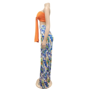 Detail of high waist wide leg pants with colorful abstract print and vibrant orange top