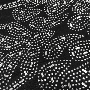 Detail of butterfly-shaped rhinestones on black sheer mesh jumpsuit fabric