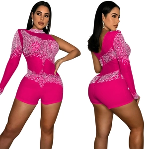 Détail d'un combishort asymétrique rose vif avec strass blancs et manche en résille