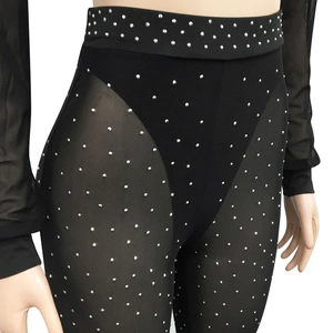 Close-up of black mesh patchwork leggings with sparkling silver rhinestones for parties
