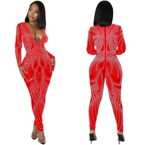 Detailed view of red long sleeve jumpsuit with symmetric white rhinestones and deep V-neck