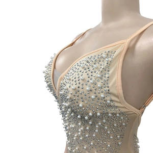 Detail view of the deep V-neck and intricate white pearls on the rhinestones dress