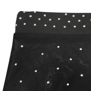 Close-up of elastic waistband and mesh fabric with silver rhinestones on black leggings