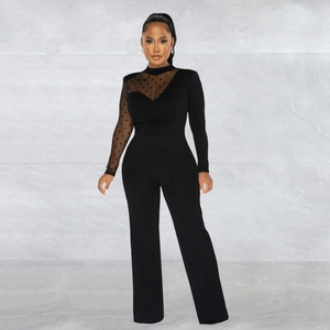 Detail of elegant black jumpsuit with polka dot mesh sleeves and high waist design