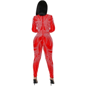 Close-up detail of silver rhinestone patterns on a red long sleeve mesh bodysuit