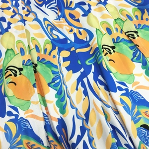Detail of vibrant tropical floral print fabric with blue and yellow hues and stitching