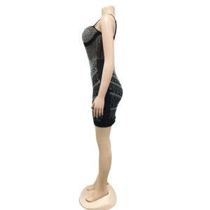 Detail view of rhinestone patterns on a black bodycon mesh dress with thin straps