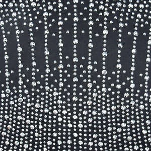 Detail von schwarzem Netzkleid mit silbernen Strasssteinen im Sternen-Verlaufsmuster