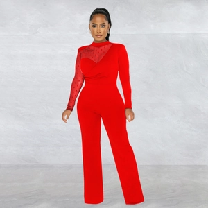 Detail of red jumpsuit showing sheer polka dot mesh sleeve and asymmetrical chest stitching