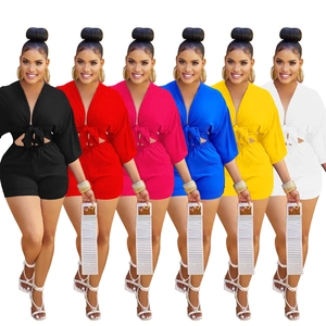 Front view of women's short jumpsuits in six vibrant colors with deep V-neck and tie detail