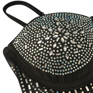 Detail of rhinestones in radial patterns on a black sheer mesh dress with spaghetti straps
