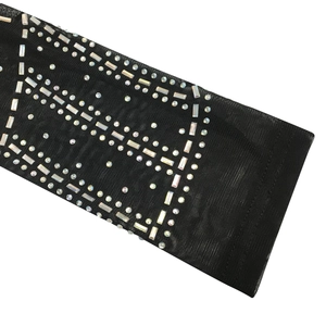 Detail of sheer black mesh fabric with iridescent rectangular rhinestones and metal beads