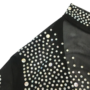 Détail de maille noire avec des strass irisés scintillants et des coutures fines