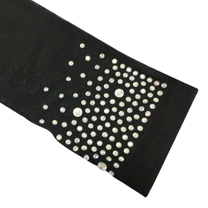 Détail d'une manche en maille noire transparente avec des strass AB étincelants