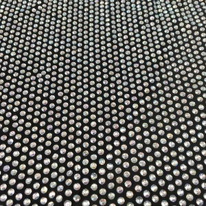 Macro shot of detailed iridescent rhinestones on black mesh fabric of sexy dress