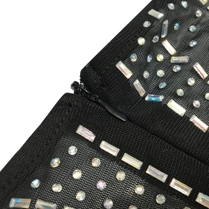 Macro detail of black mesh fabric with rainbow rhinestones and a hidden zipper