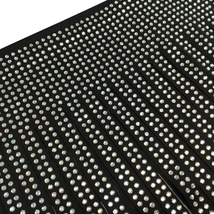 Detailed close-up of sparkling iridescent rhinestones on black fabric for party wear