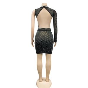 Close-up of sparkling rhinestones on an asymmetric backless black mesh party dress