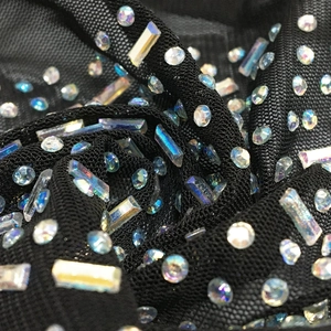Detail of black mesh fabric with iridescent rhinestones on v-neck long sleeve jumpsuit