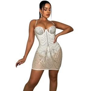 Detail of white mini dress featuring silver rhinestones and sparkling tassel patterns