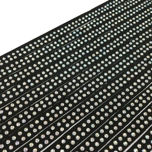 Detailed view of black rhinestone straps with double-row colorful AB crystals on fabric