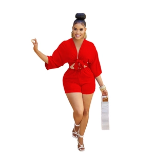 Detail of red deep V-neck tie-up crop top and high-waisted shorts set on model