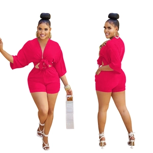 Detail of rose red two-piece set featuring a tie-front crop top and high-waisted shorts