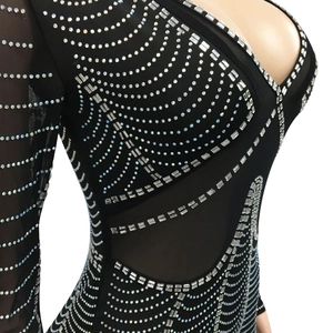 Close-up of sheer black mesh V-neck dress featuring intricate silver rhinestone patterns
