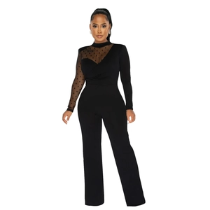 Detail of sheer polka dot mesh sleeve and asymmetrical patchwork on black jumpsuit
