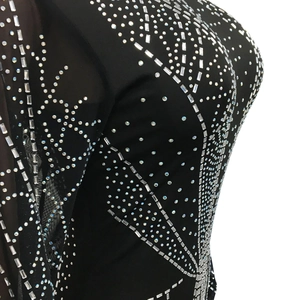 Détail de la robe en maille avec strass argentés symétriques sur tissu noir élastique