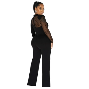 Macro detail of sheer black polka dot mesh sleeves on the elegant long jumpsuit