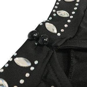 Macro detail of black mesh dress featuring sparkling rhinestones and beaded ornaments