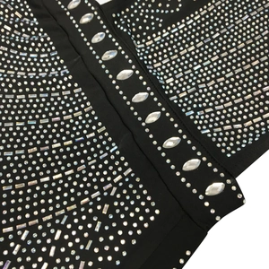 Detailed view of black mesh dress featuring intricate crystal rhinestones and beadwork
