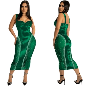 Detail of emerald green satin bodycon dress with spaghetti straps and rhinestone accents