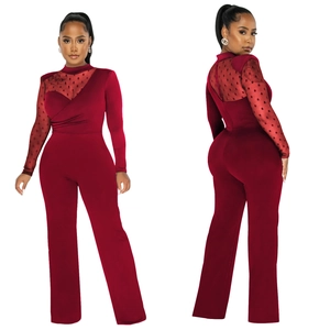 Detail view of the burgundy polka dot mesh sleeves and pleated neckline on the jumpsuit