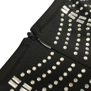 Detail of hidden zipper and sparkling rhinestones on black mesh evening dress fabric