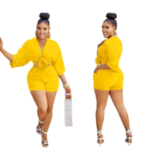 Detail of yellow V-neck crop top with front tie knot and matching high-waist shorts