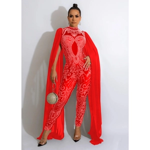 Close-up of red rhinestone jumpsuit with mesh details and long cape showing fabric textures