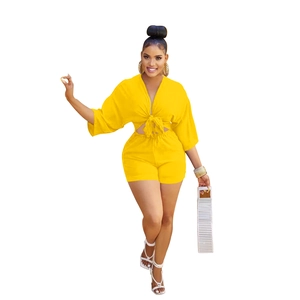 Detail of yellow two-piece set featuring a deep V-neck tie-front top and high-waist shorts