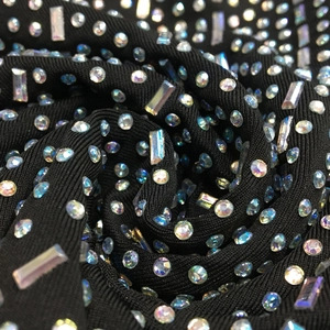 Close-up of black ribbed fabric with sparkling AB rhinestones in round and square cuts