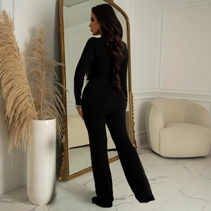 Detail view of black long sleeve jumpsuit showing slim fit back and flared hem style