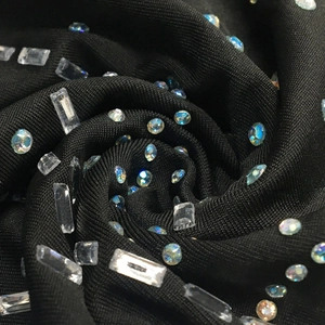 Détail macro du tissu en maille noire avec strass brillants et cristaux AB étincelants