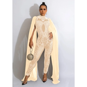 Detail of sheer mesh jumpsuit featuring intricate rhinestone patterns and long cape sleeves