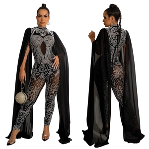 Close-up of black mesh jumpsuit with silver rhinestones and flowing floor-length shoulder cape
