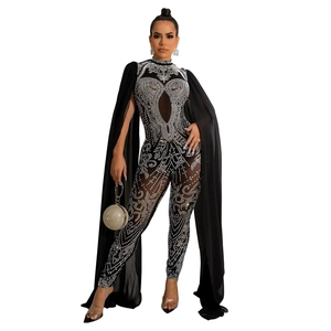 Detail of sheer black mesh jumpsuit with rhinestones and floor-length shoulder cape