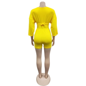Rear view of bright yellow short-sleeved romper with waist tie on mannequin