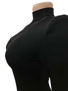 Detail of black mock neck top featuring sheer mesh patchwork with diamond pattern