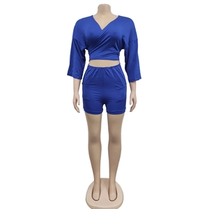 Detail of navy blue two-piece set featuring V-neck wrap crop top and high-waisted shorts