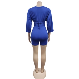 Rear view of royal blue short sleeve romper showing waist tie and slim fit tailoring