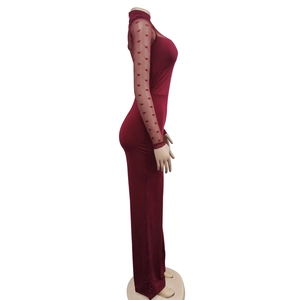 Detail view of burgundy slim jumpsuit with sheer mesh sleeves and red velvet polka dots